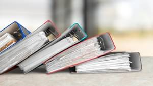 Fünf volle Ordner fächerartig auf einander gestapelt