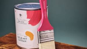 Close-Up auf einen pinken Farbeimer mit pinkem Pinsel.