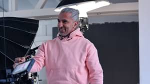 Gründer Jacob Fatih in lässigem Outfit läuft fröhlich lachend auf ein Shooting Set zu.