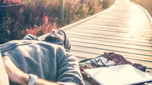 Mann liegt entspannt auf einem Steg