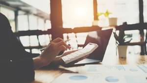 Eine Frau berechnet etwas mit einem Taschenrechner