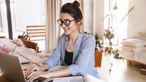 Frau mit Brille informiert sich an ihrem Laptop.