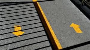 Straße mit zwei gelben, entgegenlaufenden Richtungspfeilen.