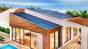 Eine Familie kniet im Garten vor dem Haus und streichelt einen Hund.