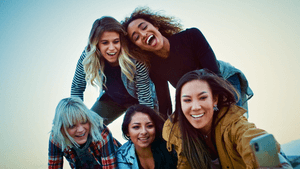 Fünf junge Frauen bilden eine Pyramide und lächeln für ein Selfie in die Kamera.