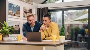 Ein Pärchen schaut gemeinsam auf einen Laptop und informieren sich über Optionen & Future. 