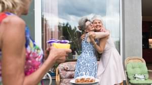 Ältere Damen, die sich freudig auf einer Feier umarmen