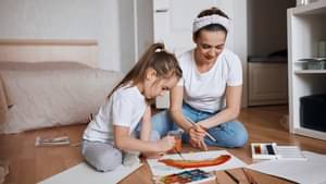 Mutter malt mit Kind einen Regenbogen