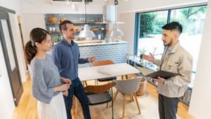 Ein Paar und ein Berater stehen in einer modernen Küche.