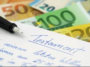 Geldscheine, handschriftliches Testament und ein Stift auf dem Tisch