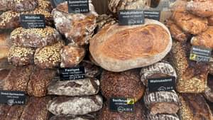 Auf einem Tisch sieht man verschiedene Brotlaibe unterschiedlicher Sorten zum Verkauf.