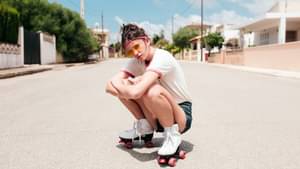 Junge Frau auf Rollschuhen hockt inmitten einer Straße. ETF