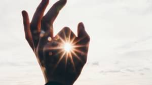 Hand die eine halbe Faust macht, wo die Sonne durchscheint