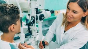 Augenärztin untersucht die Augen eines jungen Patienten.