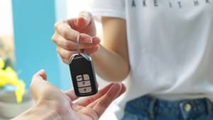 Frau gibt ihren Autoschlüssel einer anderen Person.