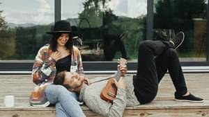 Pärchen sitzt auf einer Holzterrasse vor dessen Haus.