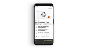 Auf dem Bildschirm eines schwarzen Smartphones ist die Commerzbank Banking App zu sehen. Die Virtual Debit Card ist eingeblendet und darunter die Schritt für Schritt Anleitung, wie man die Virtual Debit Card beantragen und einrichten kann.